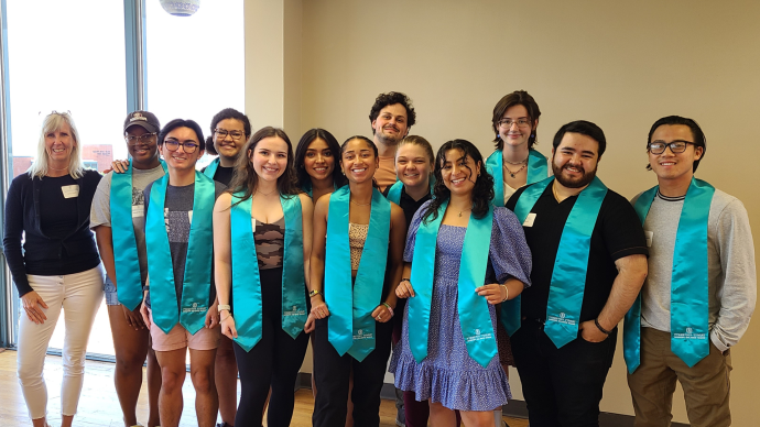 Graduating McNair Scholars pose with their stoles and program director, Kelly Lyons