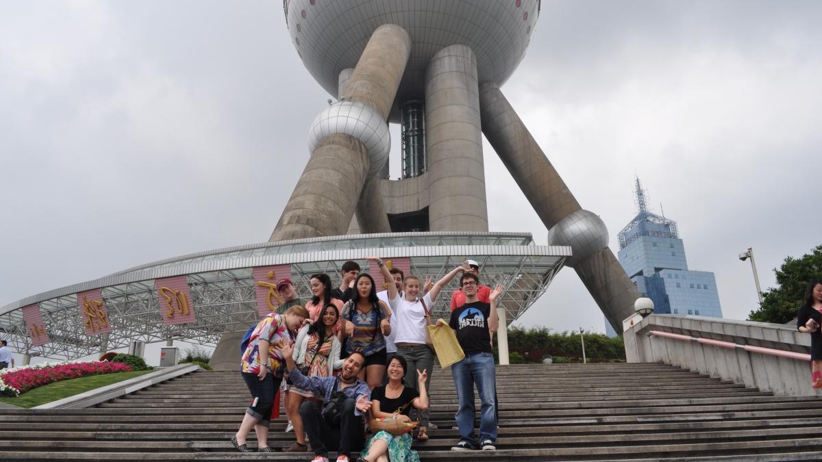 Trinity students gather on steps in front of the Oriental Pearl Radio & Television Tower in Shanghai